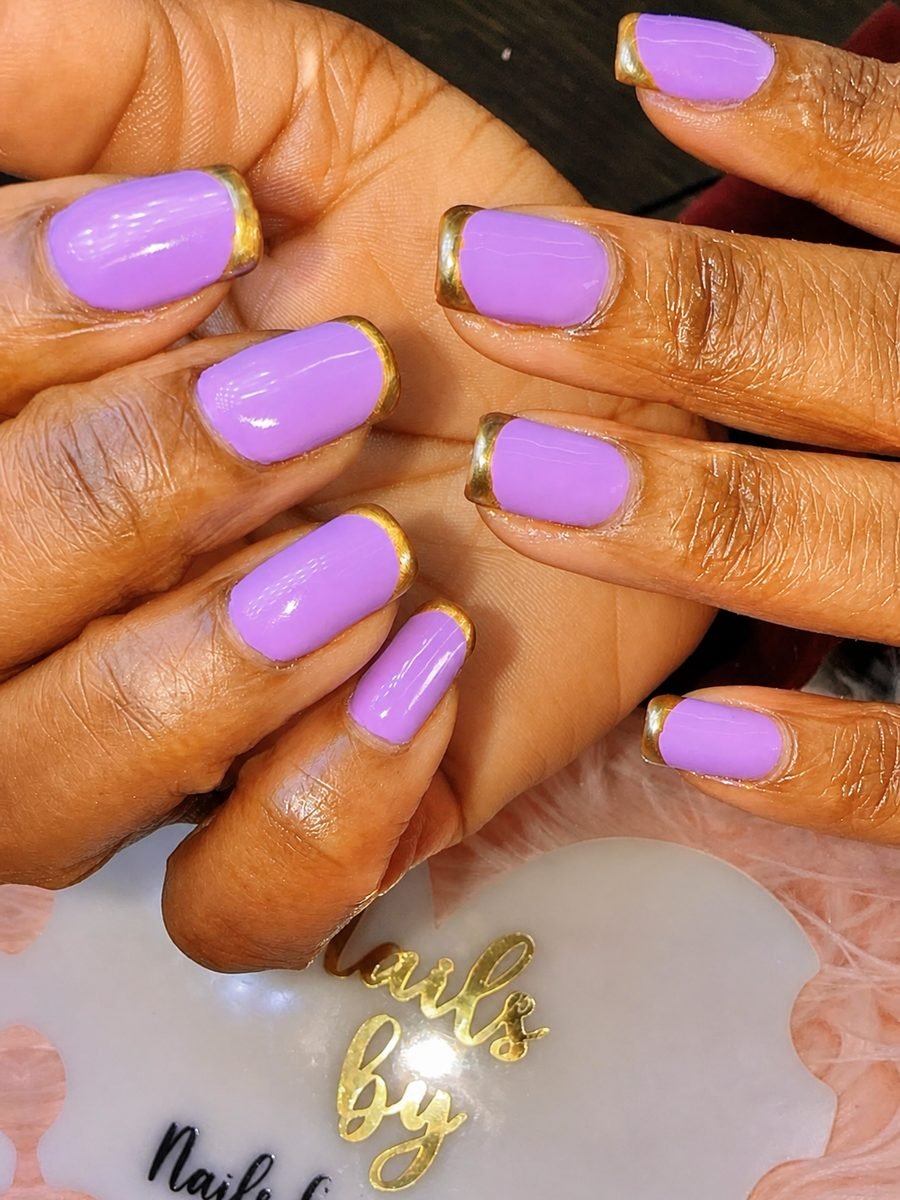 Lilac gel nails finished with metallic gold chrome French tips